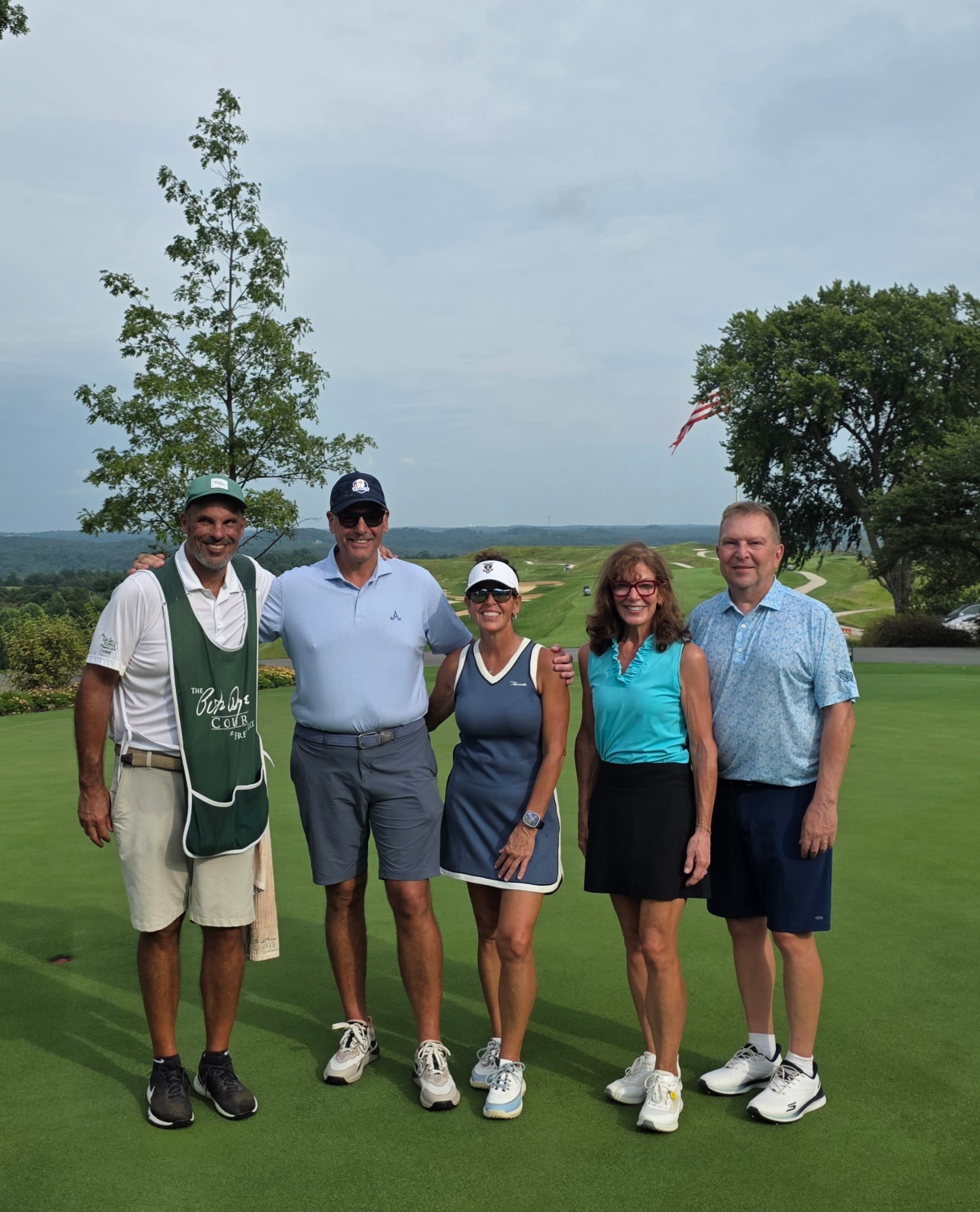 The group on the Pete Dye Course — caddie, players, and the Indiana hills behind